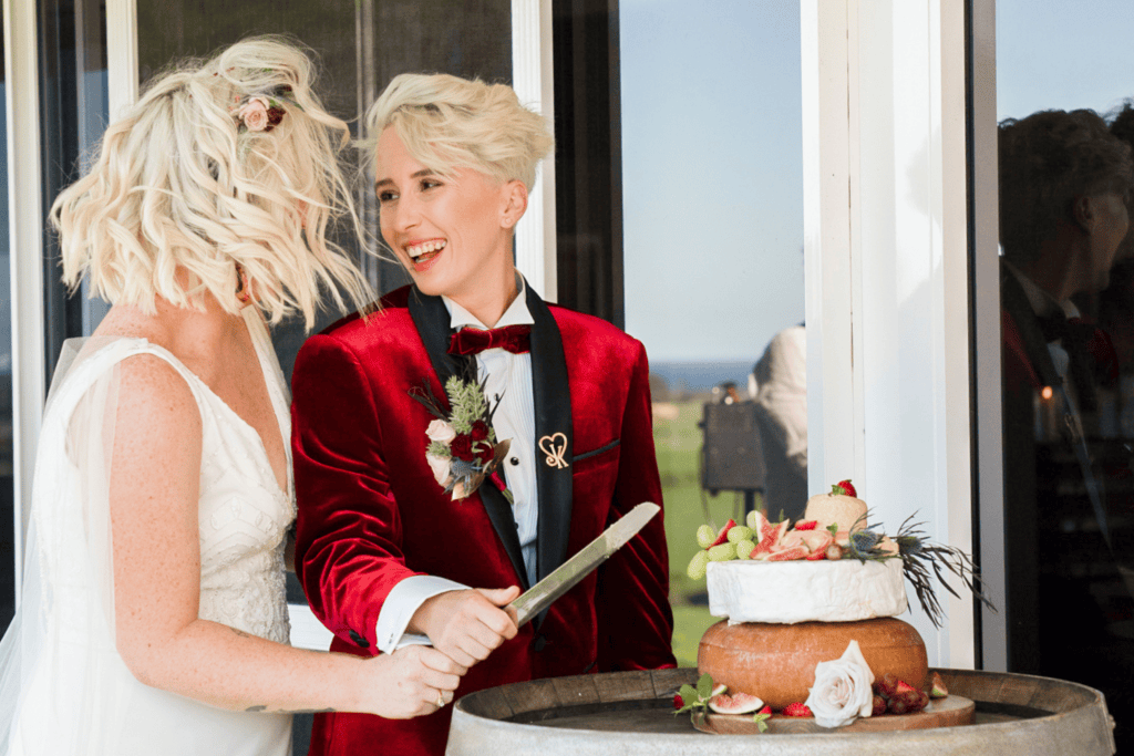 same sex wedding bride and bride cutting cake at winery