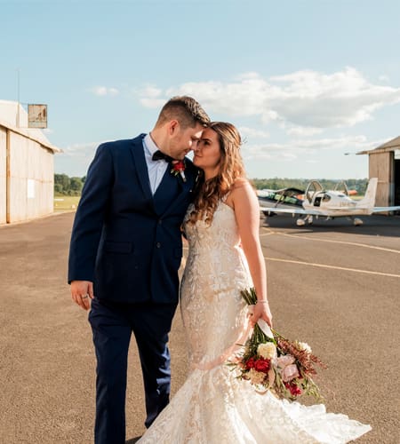 1 bride and groom cuddling at camden airport on wedding day