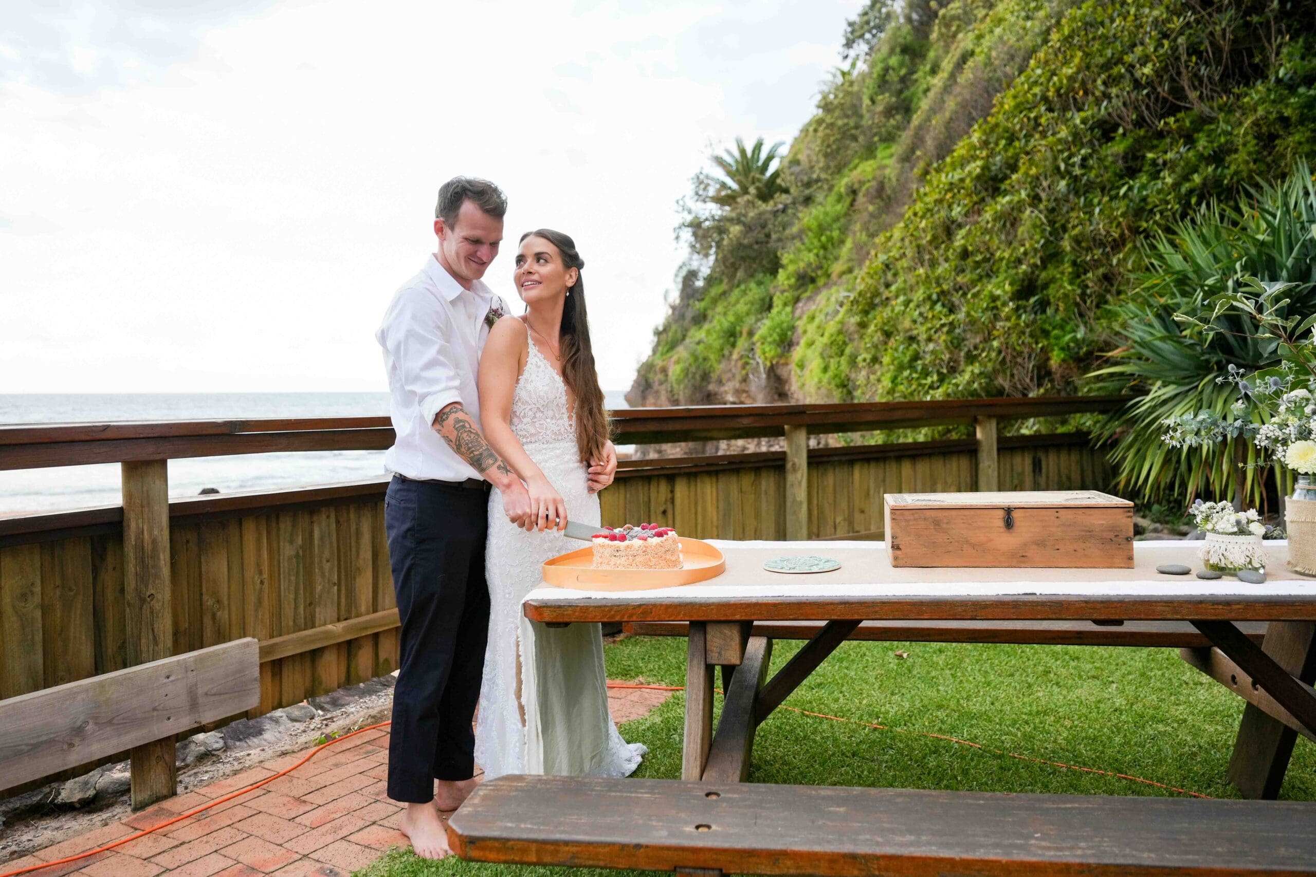 bride and groom cutting wedding cake at sunset in Sydney
