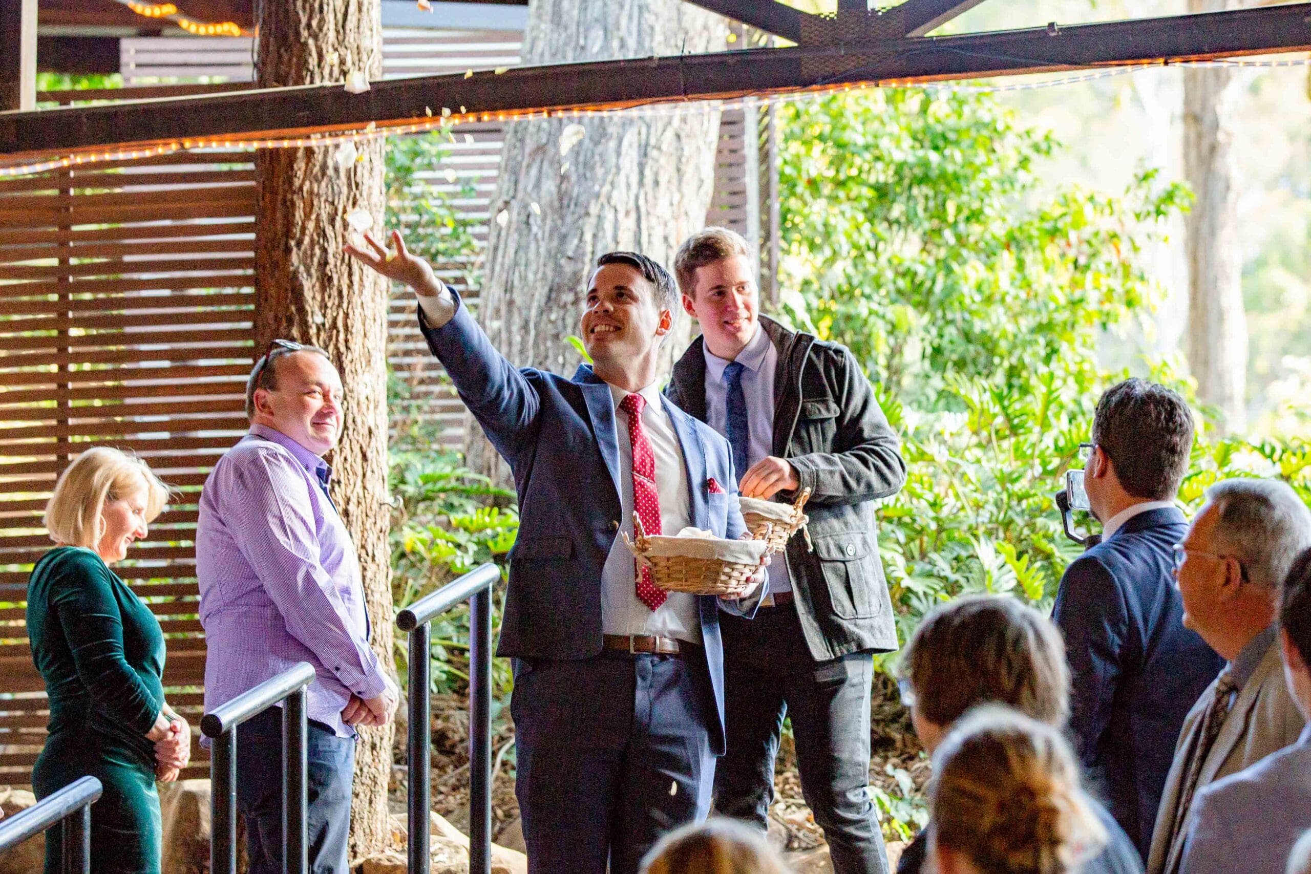 flower boy throwing confetti at Brisbane wedding