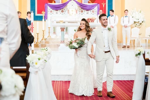 Newly wed couple walking down the aisle of a Western Australia cathedral.