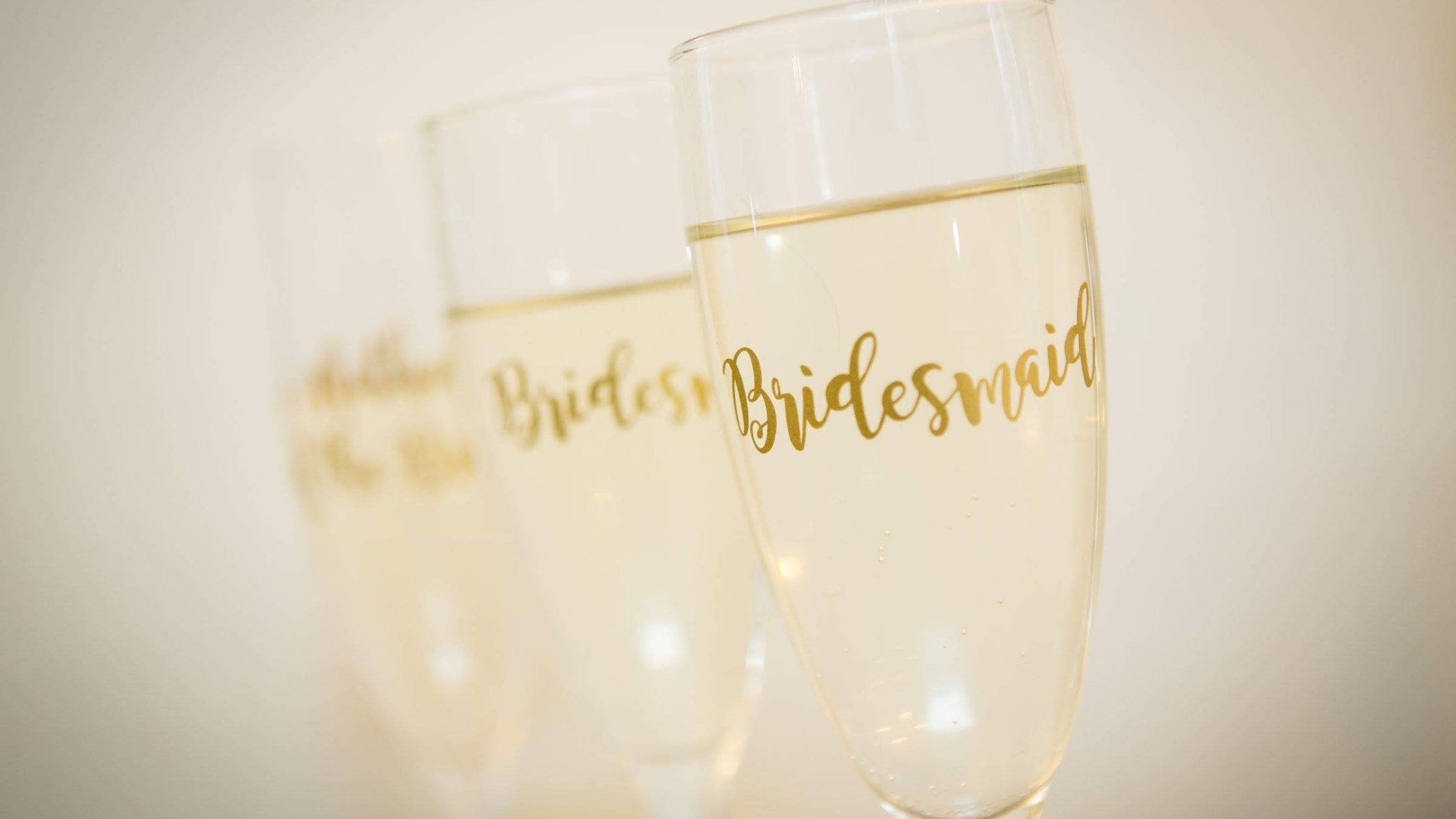 Wine Glasses with 'bridesmaid' written on them in gold.