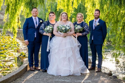 Bride and Bridal party standing in front of river.