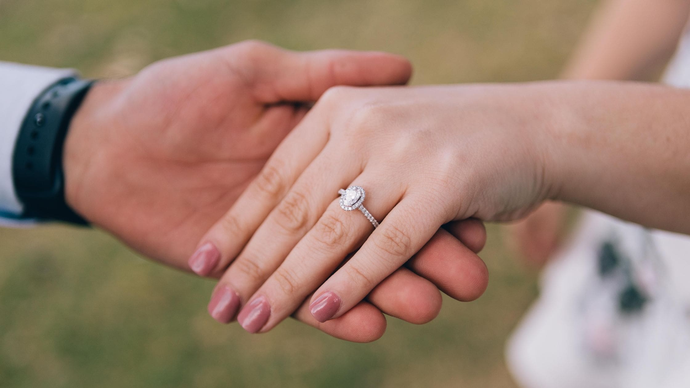 Couple holdinh hands showing off engagement ring