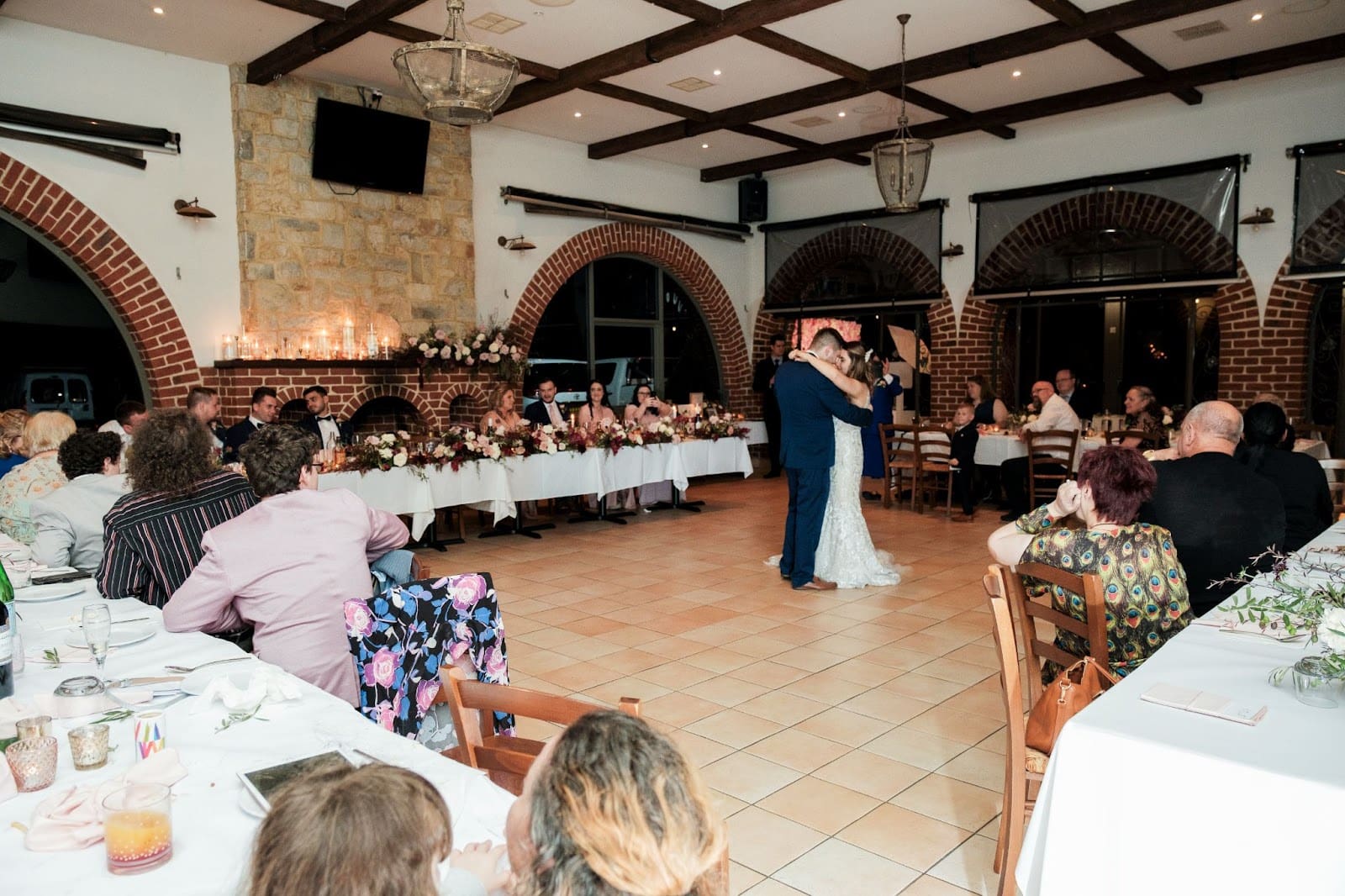 Newly-weds sharing their first dance while their guests watch on from their tables. 