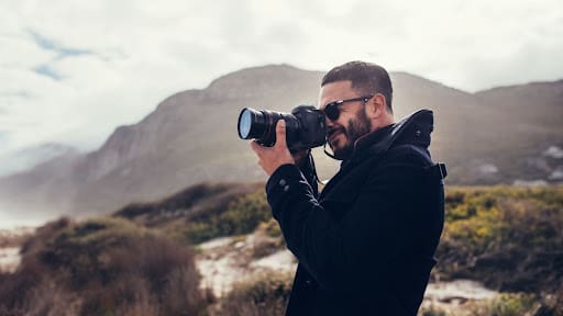 Photographer looking through camera lens to take a shot.