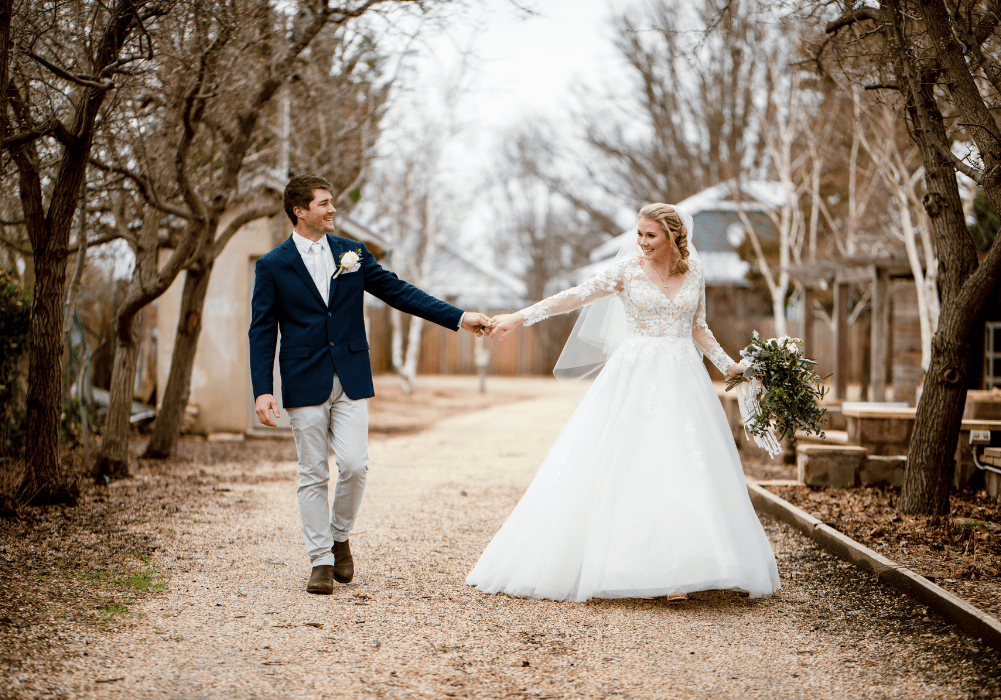 1 Bride and groom holding hands under winter trees