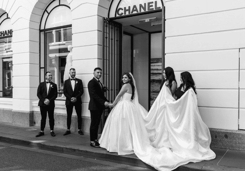 bridal party posing for wedding photographer outside of Chanel in Melbourne