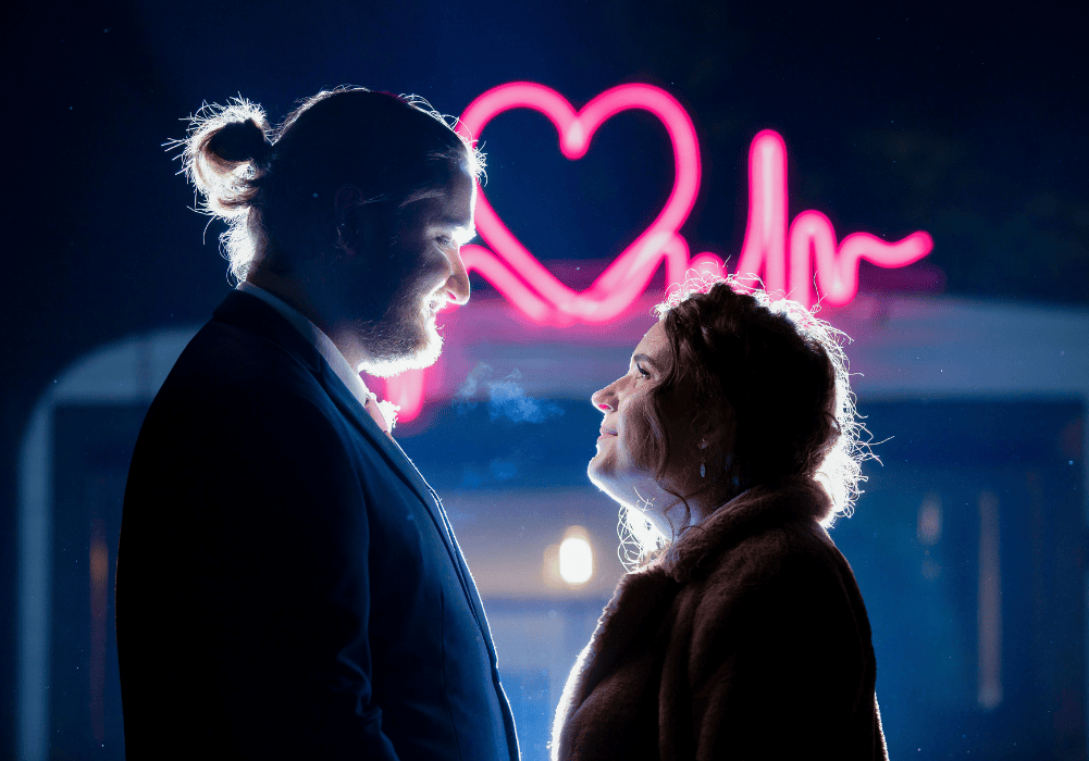 1 Esther and Shannon in front of neon heart photographed at wedding