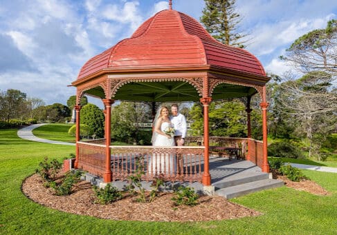Newly weds posing in garden pergola.